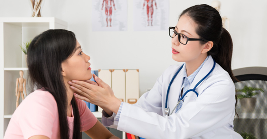 Female-doctor-examining-female-patient’s-jaw-and-neck