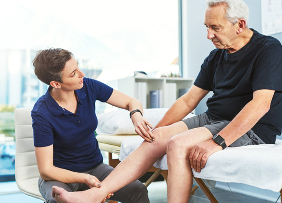 Female-healthcare-professional-examining-senior-male-patient’s-knee