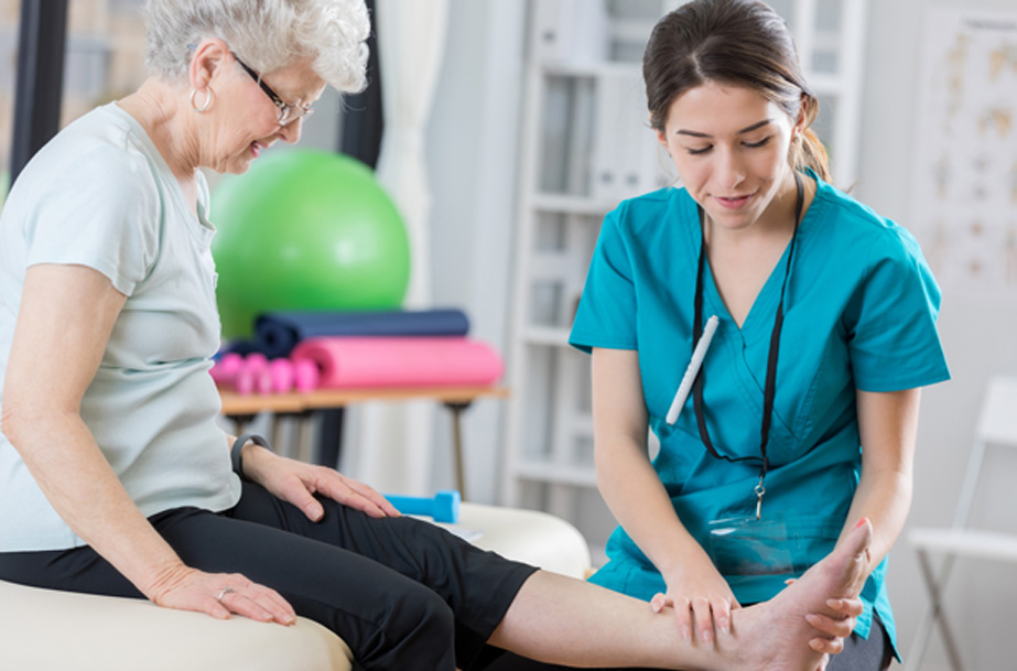 Physical-therapist-examining-a-female-senior-patient’s-ankle