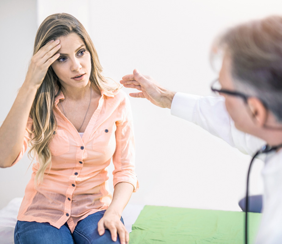 Woman-speaking-to-her-doctor-about-migraine-headaches